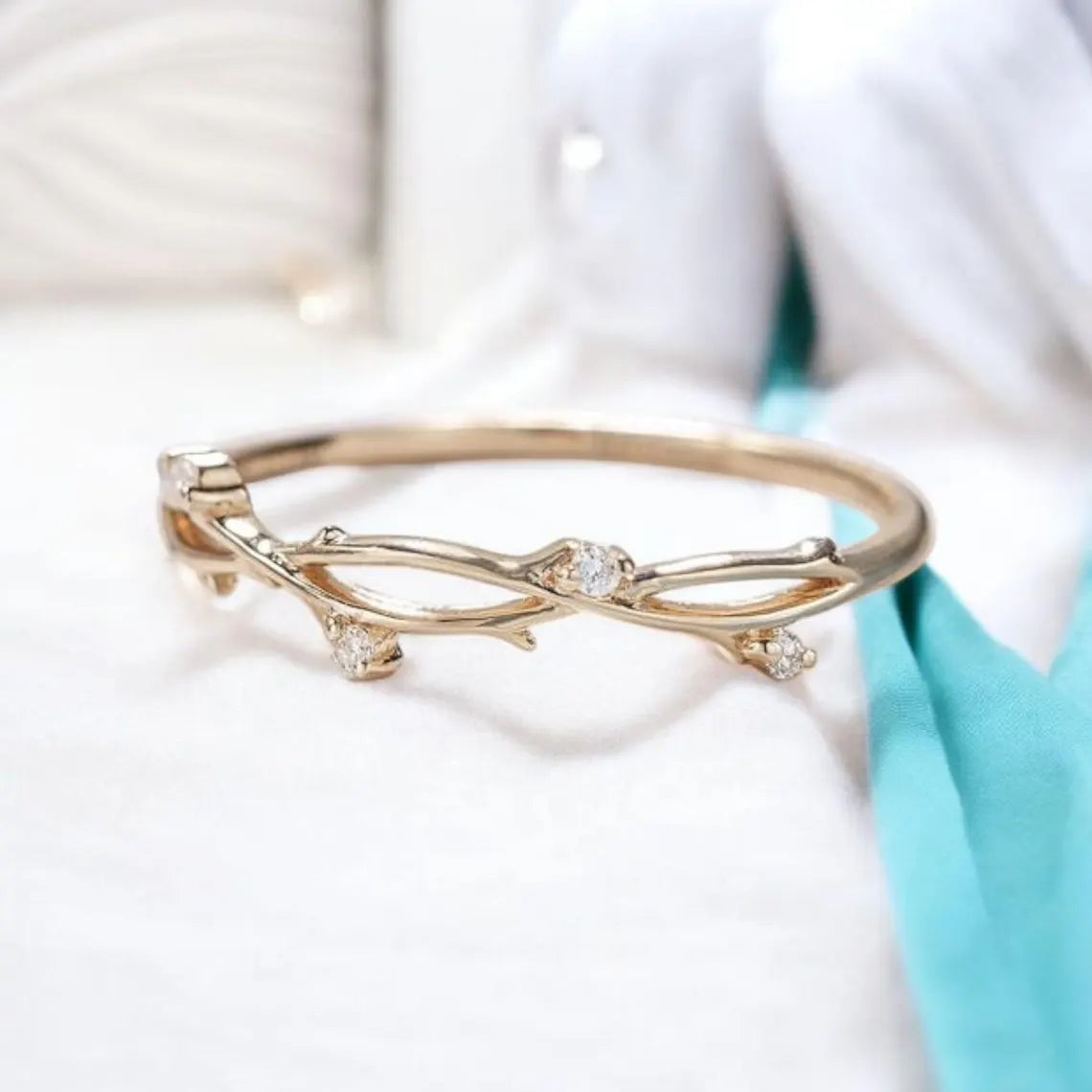 Gold bracelet with diamond-like stones on a white background