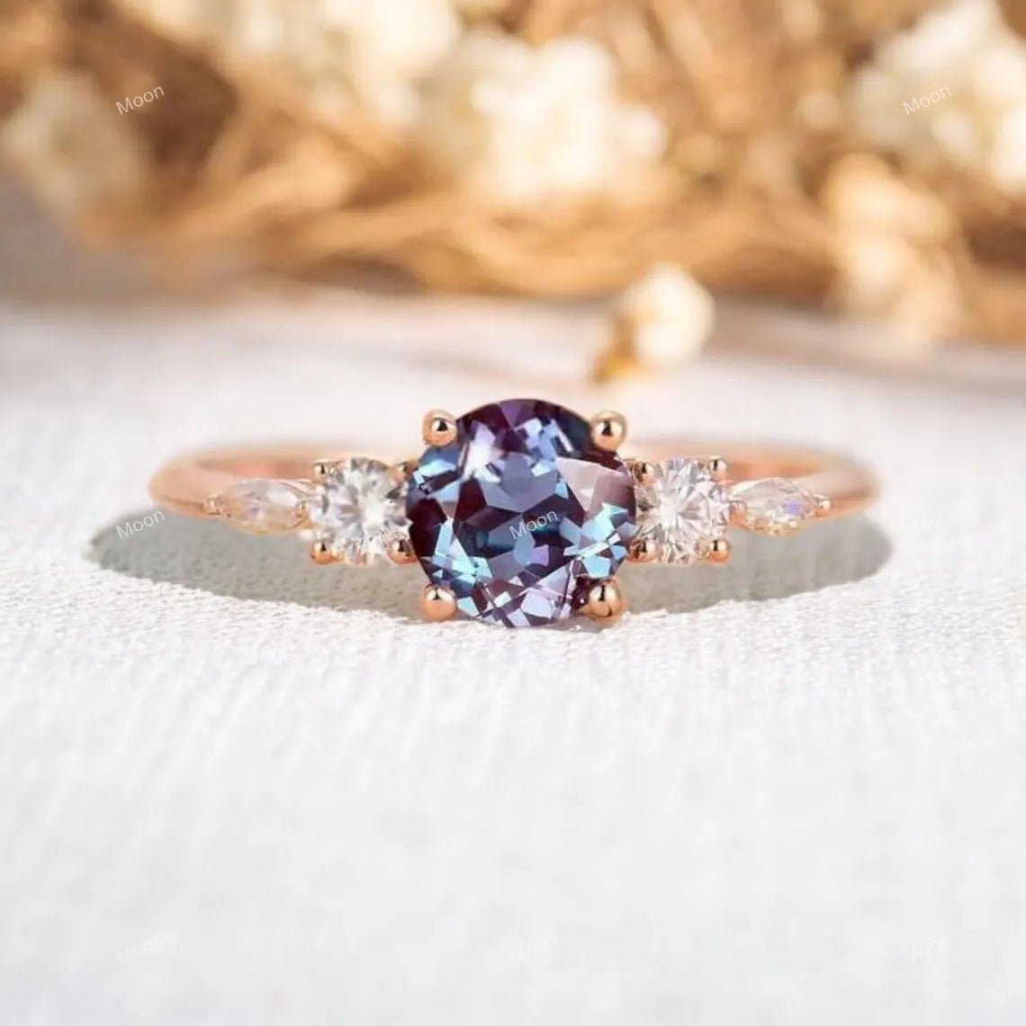 Ring with a purple gemstone and rose gold band on a white background